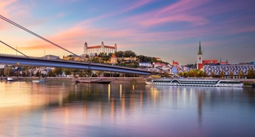 Bratislava Sehenswürdigkeiten: Blick auf die Burg von Bratislava, die Altstadt und eine Brücke im Abendlicht. 