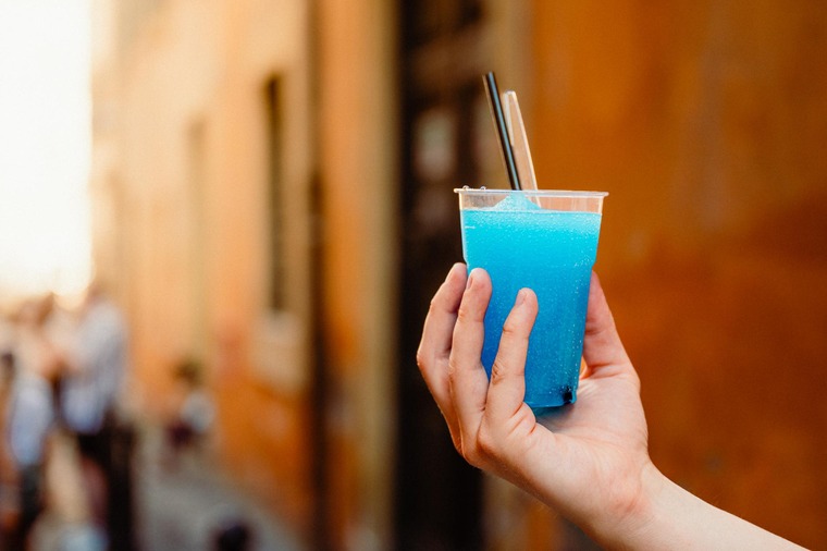 Geheimtipps für Rom: Unbedigt Grattachecca probieren! Das geschabte Eis mit Geschmack – im Bild in Blau, in einem Plastikbecher, der von einer Hand gehalten wird – kühlt an heißen Sommertagen wunderbar!