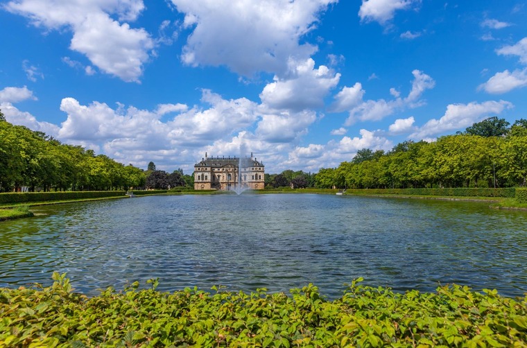 Zu den Dresden Sehenswürdigkeiten gehört der Große Garten. Auf dem Bild sieht man das Sommerpalais im Hintergrund, im Vordergrund ein weitläufiger Teich. 