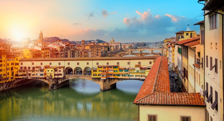 Zu den Florenz Sehenswürdigkeiten gehört die Ponte Vecchio. Auf dem Bild sieht man sie in der goldenen Stunde.