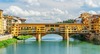 Zu den top Sehenswürdigkeiten in Florenz gehört die Brücke Ponte Vecchio. Auf dem Bild sieht man sie an einem sonnigen Tag. 
