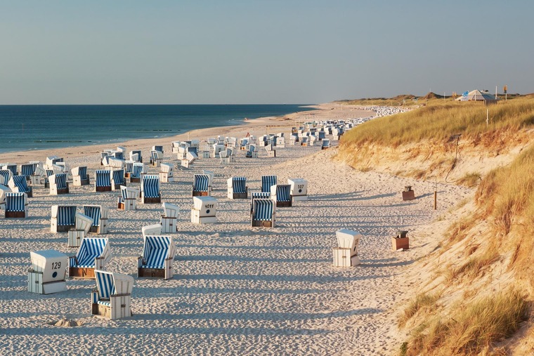 Mit dem Zug zum Meer: Strand mit Strandkörben und Dünen im Abendlicht nahe Kampen auf Sylt an der Nordsee, Schleswig-Holstein, Deutschland.
