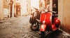 Geheimtipps Rom: Ein römische Gasse im sanften Licht, vorne sieht man eine rote Vespa. 