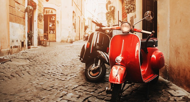 Geheimtipps Rom: Ein römische Gasse im sanften Licht, vorne sieht man eine rote Vespa. 