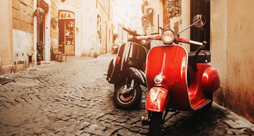 Geheimtipps Rom: Ein römische Gasse im sanften Licht, vorne sieht man eine rote Vespa. 