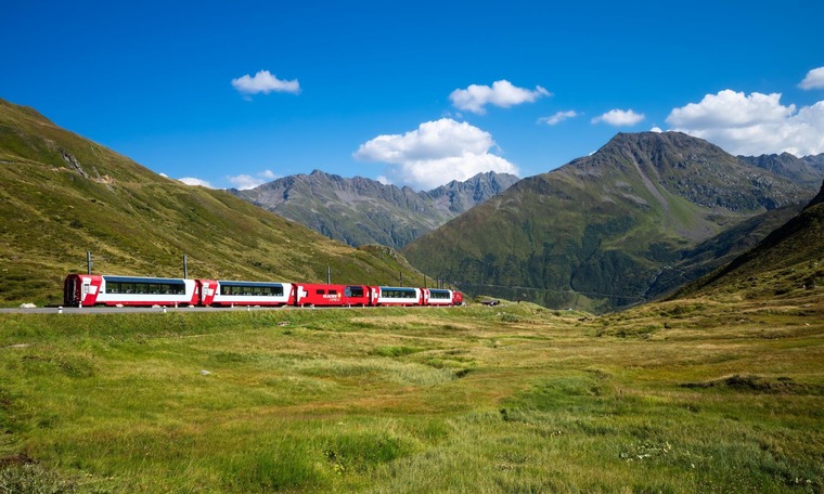 Auf der Glacier Express Route liegt der Oberalppass. Auf dem Bild sieht man den Glacier Express am grünen Oberalppass.