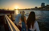 Hamburg Highlights: Drei junge Menschen stehen bei Sonnenuntergang am Hamburger Hafen und blicken in Richtung Meer