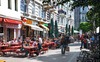Hamburg Highlights: Ein Blick auf eine belebte Straße im Schanzenviertel, Menschen sitzen in Gastgärten in der Sonne
