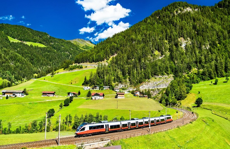 Mit den schönsten Interrail Routen den Alpenraum entdecken. Auf dem Bild sieht man einen Zug am Brennerpass.