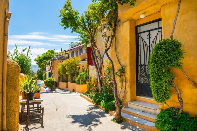 Interrail Routen: Diese Route führt bis nach Athen. Auf dem Bild sind alte, gelbe Häuser eines Athener Viertels zu sehen. 