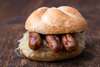 Sehenswürdigkeiten von Nürnberg für den Gaumen: Drei Nürnberger Rostbratwürste mit Sauerkraut in einer Semmel.