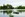 Zu den Sehenswürdigkeiten von Paris gehört der Bois de Vincennes. Im Bild sieht man einen See samt Ruderboot, im Hintergrund das Grün des Parks. 