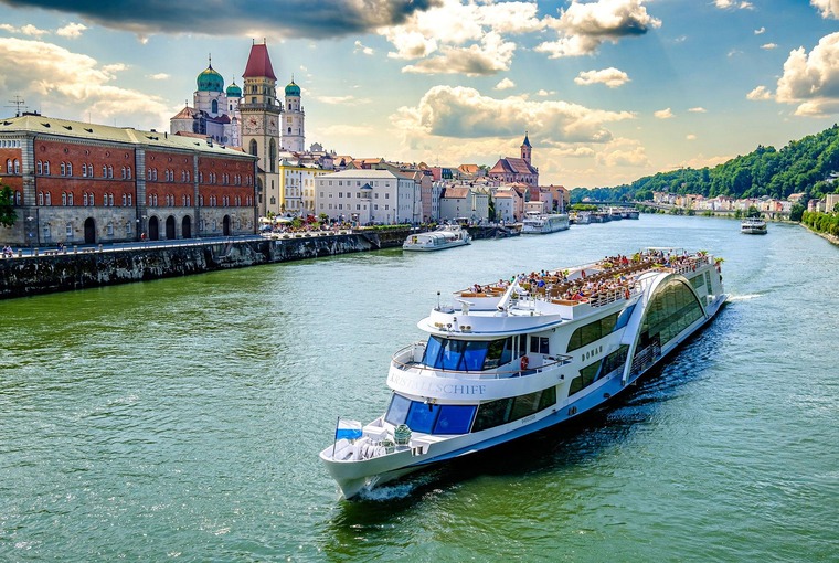 Passau Sehenswürdigkeiten erlebt man mit dem Schiff. Auf dem Bild sieht man ein Boot vor der historischen Altstadt.