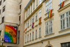 Zu den top Queer-Events Europas zählt neben der Vienna Pride, verschiedene Christopher Street Days und auch die Bratislava Pride. Auf dem Bild sieht man eine Häuserfront, die mit Regenbogen-Fahnen und Plakaten behängt ist. 