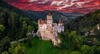 Wer mit dem Zug nach Rumänien fährt, sollte einen Stopp beim Schloss Bran in Brașov einlegen. Auf dem Bild sieht man das Dracula-Schloss Bran unter einem roten Abendhimmel. 