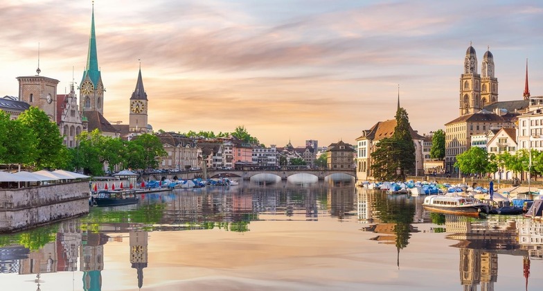Sehenswürdigkeiten in Zürich: Abendlicher Blick auf die Innenstadt von Zürich vom Wasser aus. 
