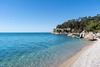 Triest Sehenswürdigkeiten: Der Strand Grignano, ganz in der Nähe des Schlosses Miramare, unter blauem Himmel und bei Sonnenschein. 