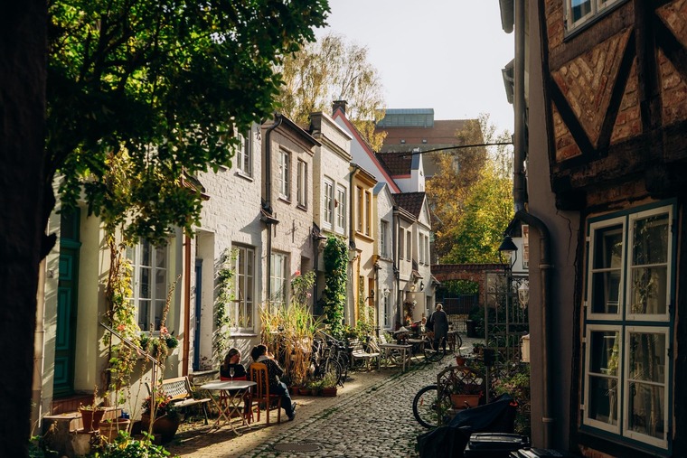 Ostsee-Urlaub: Eine Gasse in der Hansestadt Lübeck, Kopfsteinpflaster und ältere Häuser im Abendlicht. 