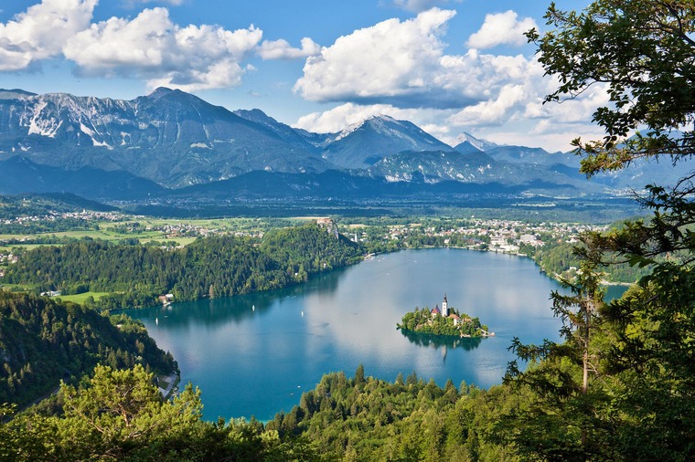 Zu einem Urlaub in Slowenien gehört ein Besuch am Bleder See. Auf dem Bild sieht man den See und die kleine Insel in der Mitte.