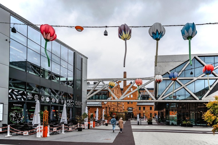 Zu den Warschau Sehenswürdigkeiten gehört das Stadtviertel Praga. Auf dem Bild zu sehen die modern gestaltete „Koneser Vodka Fabrik“ mit einer hängenden Kunstinstallation aus überdimensionalen Tulpen. 