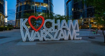 Sehenswürdigkeiten Warschau: Auf dem Bild zu sehen ist ein LED-Lichtschild, in den Nachtstunden der Stadt, mit der Aufschrift „Kocham Warszawe", was auf Deutsch „Ich liebe Warschau" bedeutet.