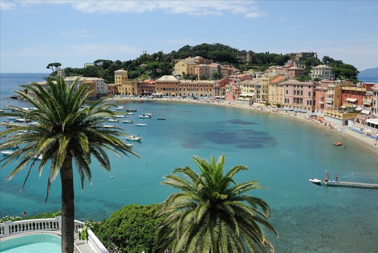 Genua Sehenswürdigkeiten: Blick auf Sandstrand mit Palmen und türkisem Meer in Sestri Levante