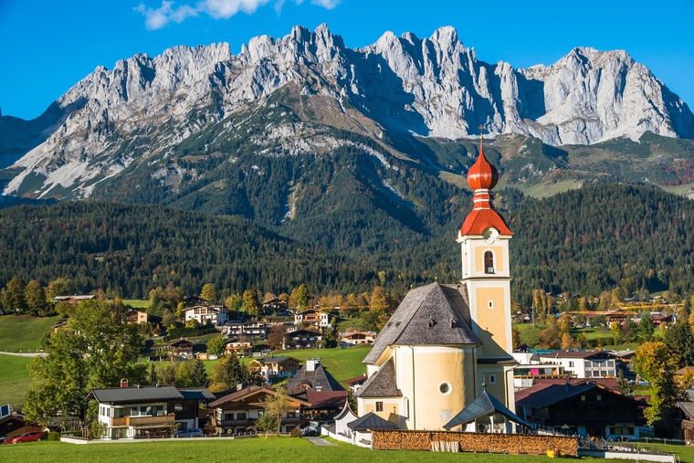 Drehorte Bergdoktor: Das Bild zeigt die schöne Aussicht auf die Heilige Kreuz Kirche und das Dorf Going am Wilden Kaiser in Tirol, Österreich.