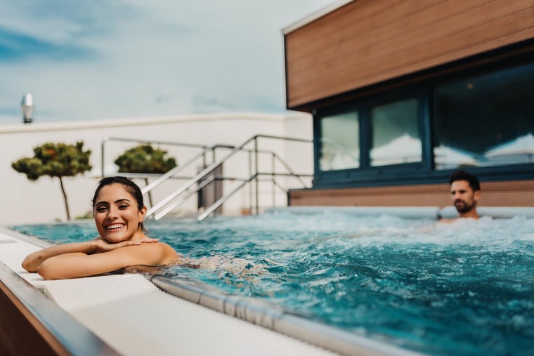 Wellness in Österreich: Frau entspannt am Poolrand der KärntenTherme in Warmbad-Villach