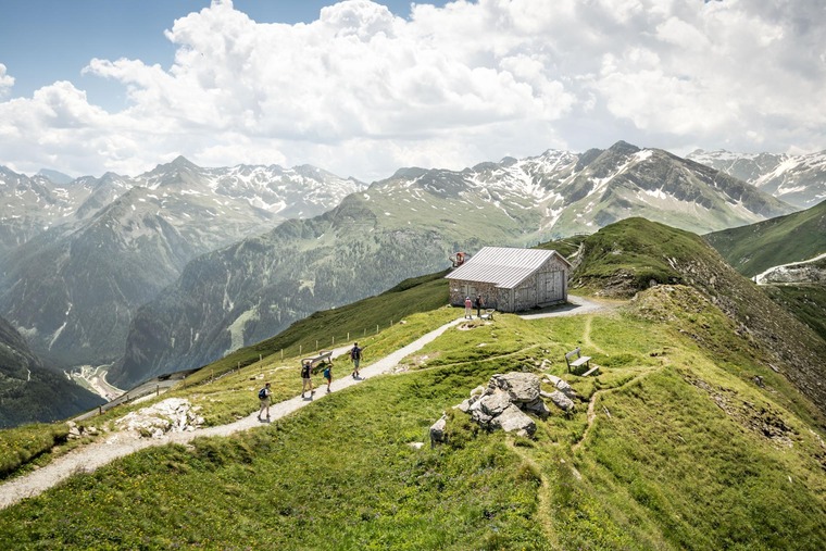 Zum Wandern bei Salzburg gehört der Stubnerkogel. Auf dem Bild sieht man Wandersleute vor einer Hütte.