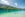 Urlaub am Weissensee: 2 Personen schwimmen im Weissensee, im Hintergrund ist auf dem See ein Ruderboot sichtbar.