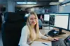Frau mit langen blonden Haaren am Bildschirm sitzend 