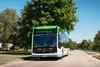 Ein ÖBB Postbus in weiß-grün auf einer Straße fahrend.