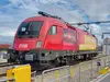 Ein Triebwagen des Güterverkehrs in rot mit Aufschrift stehend.