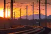 Gleisbogen mit Bahnstromanlagen im Abendrot
