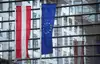 Österreich- und EU-Flagge vor verglastem Gebäude
