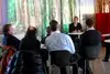 TeilnehmerInnen, die dem Vortragenden zuhören