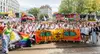 Ein Gruppenfoto aller ÖBBler:innen auf der Regenbogenparade. Mit Pride Flag und vielen Schildern. Ganz vorne ein oranges Banner mit Tigeraugen und der Aufschrift: „Tiger Stripes are not straight“.