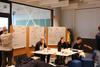 Teams entwickeln und diskutieren Projektideen an Whiteboards.
