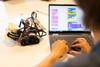 Teilnehmende programmieren und testen eine robotergestützte Lösung.
