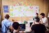 Ein Team entwickelt beim Hack4Rail 2026 Ideen mithilfe von Post-its und Laptops.