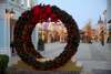 Zu den Sehenswürdigkeiten bei Eisenstadt gehört das Designer Outlet Parndorf. Auf dem Bild sieht man einen großen Weihnachtskranz auf der Straße zwischen den Boutiquen. 