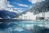Wellness in Österreich: Blick auf den Außenpool der Felsentherme in Bad Gastein, dahinter schneebdeckte Gipfel. 