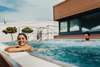 Wellness in Österreich: Frau entspannt am Poolrand der KärntenTherme in Warmbad-Villach