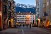 DIE Sehenswürdigkeit in Innsbruck: das Goldene Dachl in der Altstadt. Im Bild vor dem Hintergrund schneebedeckter Berggipfel.  