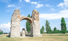 Tagesausflug ab Wien: In der Römerstadt Carnuntum wird Geschichte lebendig. Auf dem Bild sieht man einen alten, verfallenen Torbogen. 