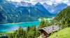 Tirol Ausflugsziele: Blick auf den Tiroler Achensee mit den Bergen im Hintergrund. Im Vordergrund eine Almhütte. 