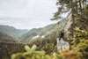 Wanderin sitzt und blickt in Richtung Hintergebirge