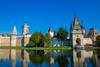 Ausflugziele rund um Wien - Das Schloss Laxenburg. Am unteren Teil des Bildes sieht man Wasser und darüber das beeindruckende Schloss mit einem Turm.
