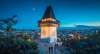 Graz Sehenswürdigkeiten: Blick auf den Grazer Uhrturm und die dahinterliegende Stadt bei Nacht. 