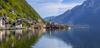 Zug nach Hallstatt: Auf dem Bild sieht man den Blick auf den See mit historischen Häusern und den Bergen des Salzkammerguts.